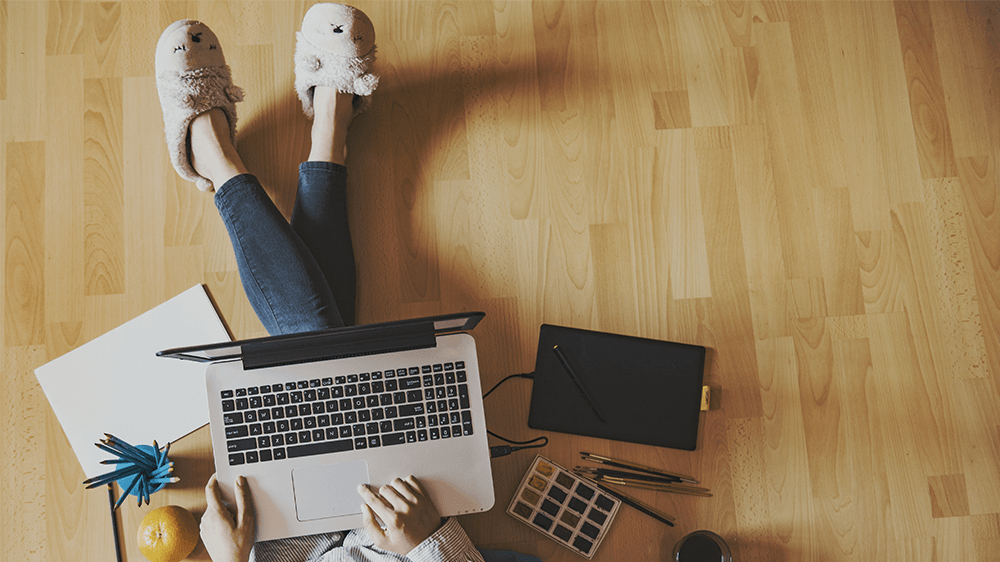 woman sitting on floor working on laptop